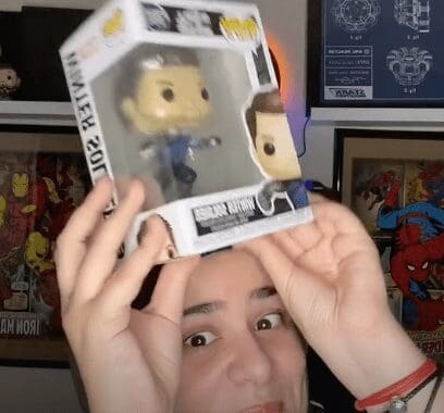 a woman holding a Funko Pop toy