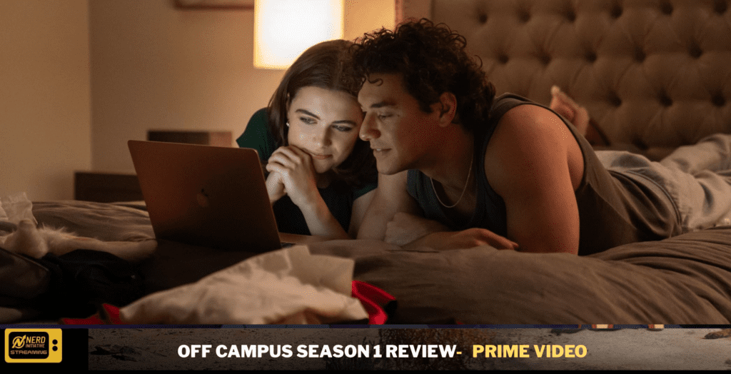 Couple lying on a bed, propped on elbows, watching a laptop screen in a cozy, dimly lit bedroom.