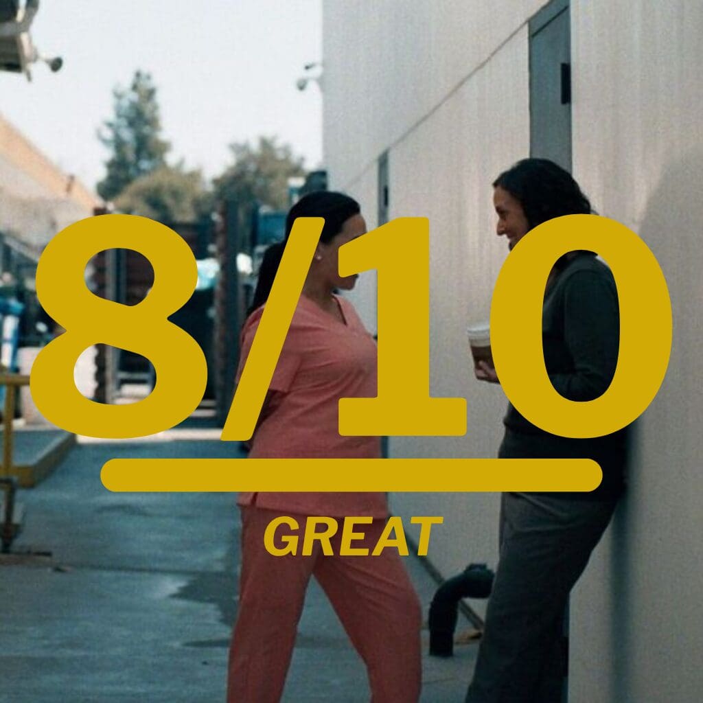 Two people standing and talking in an alley with a large yellow '8/10' and the word GREAT overlay to indicate a rating.