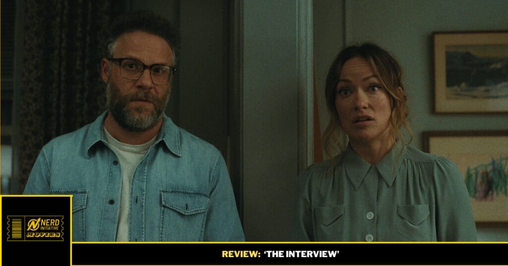 Two adults stand in a doorway, both looking at the camera with surprised expressions.